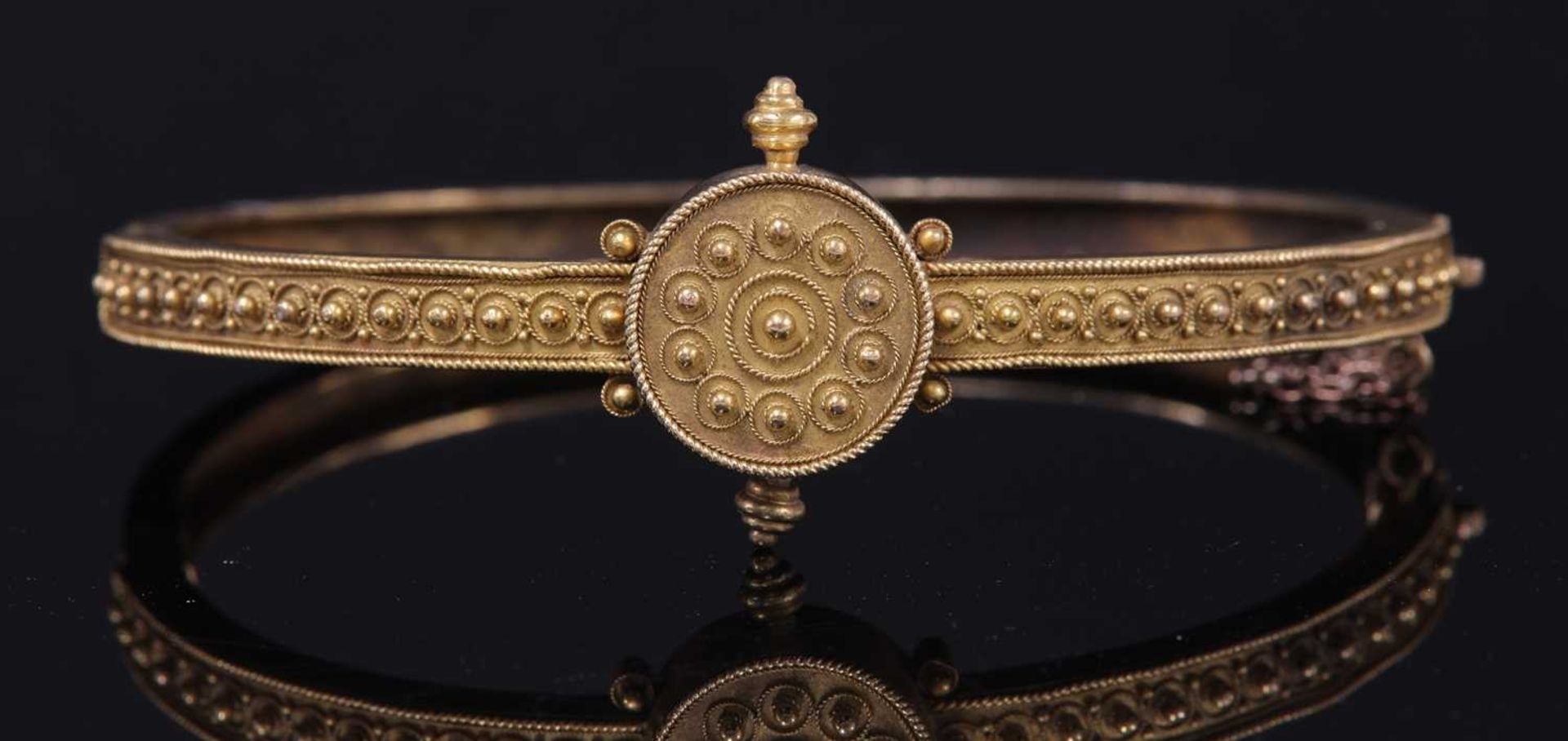 A Victorian Archaeological Revival Etruscan-style gold hinged bangle, c.1870,