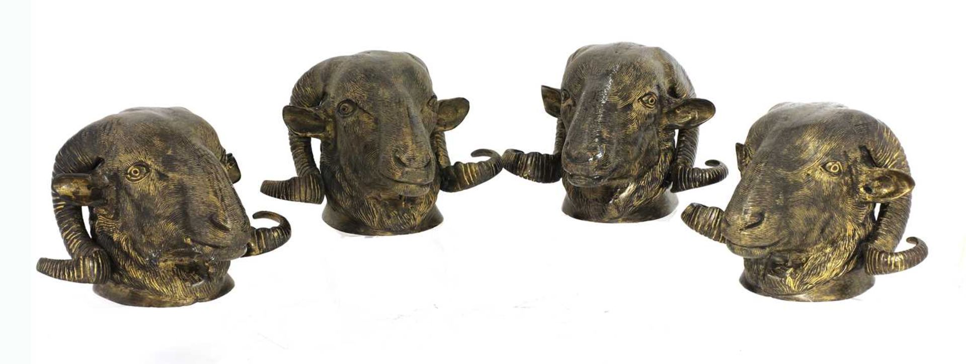 A set of four gilded metal ram's head curtain pole finials,