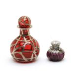 A small amethyst glass and white metal scent bottle of squat form,