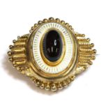 A Victorian Etruscan Revival gold garnet and enamel shield form brooch, c.1860,