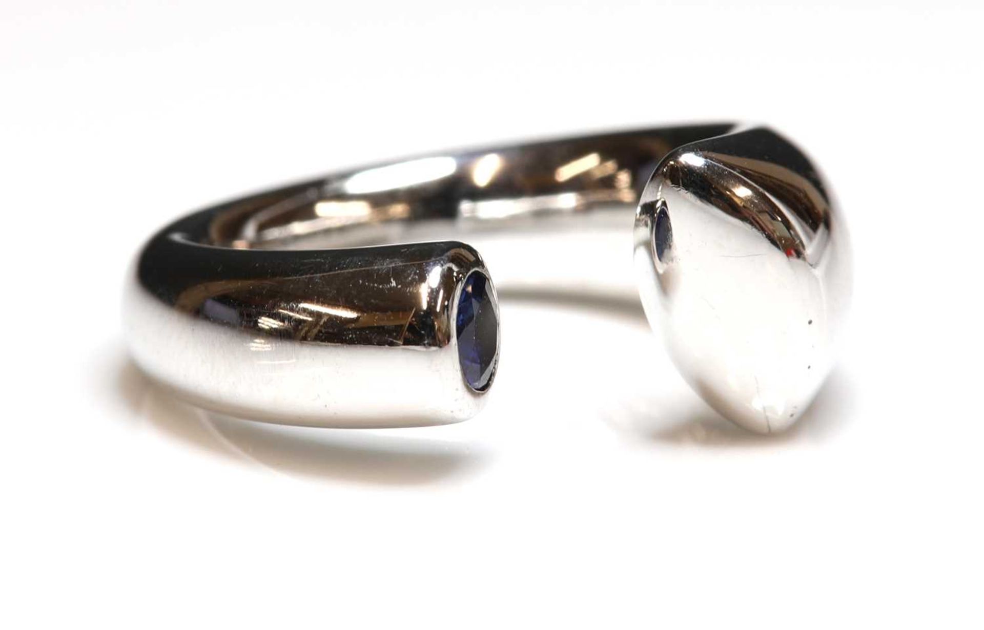 An 18ct white gold single stone sapphire torque ring,