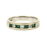A white gold diamond and emerald half eternity ring,