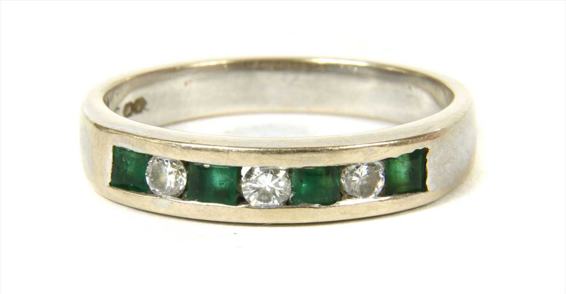 A white gold diamond and emerald half eternity ring,