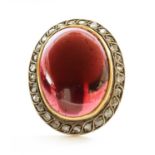A cabochon garnet and diamond oval cluster,