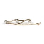 A gold three stone diamond bar brooch,