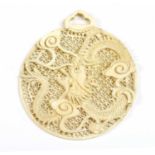 A carved pierced ivory pendant,