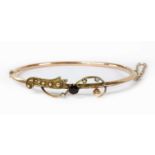 A hollow gold garnet and split pearl bangle,