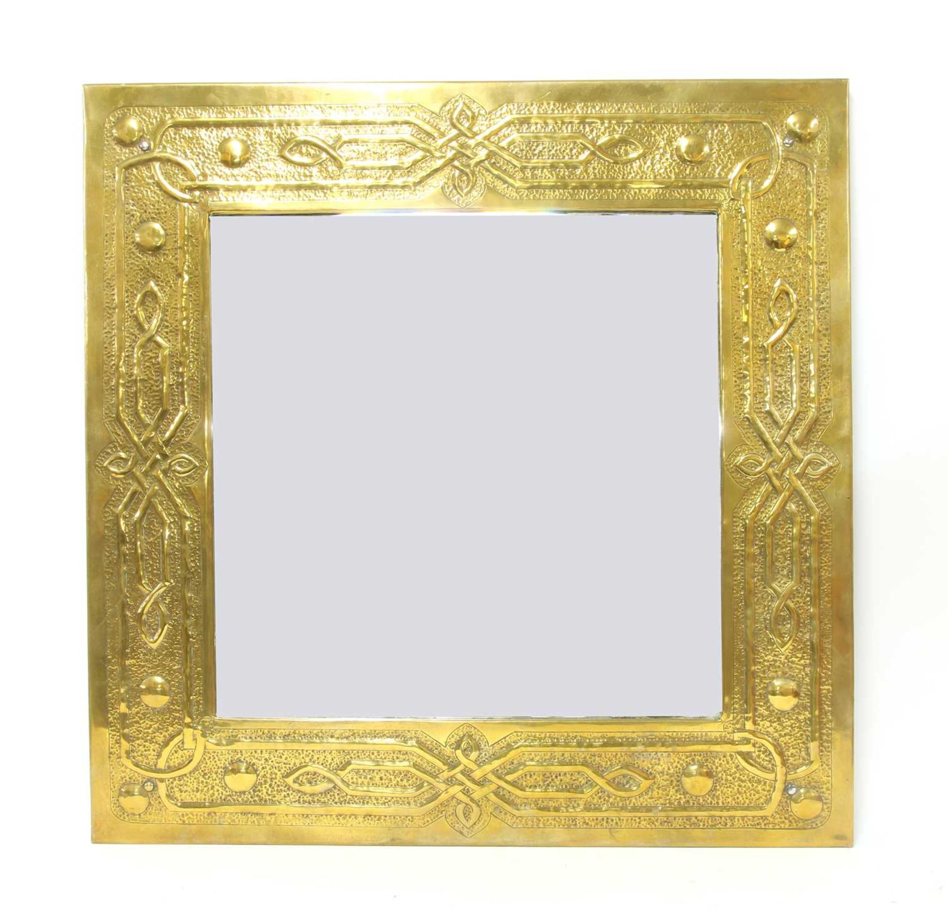 An Arts and Crafts embossed brass mirror,