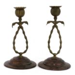 A pair of brass and copper candlesticks,