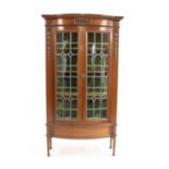 An early 20th century mahogany glazed serpentine fronted display cabinet,