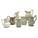 A large collection of stoneware relief-moulded jugs