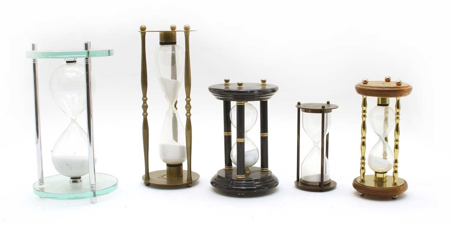 A collection of five hourglass sand timers,