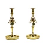 A pair of 18th century brass candlesticks with bell columns and galleried tray bases,