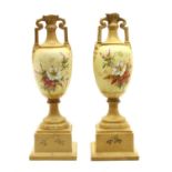 A pair of Vienna porcelain twin-handled urns on stands