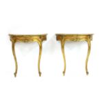 A pair of giltwood demi-lune marble topped console tables,