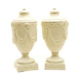 A pair of Wedgwood embossed Queensware urns,