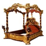 An elaborately carved and gilded four post bed,