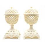 A pair of modern pierced creamware lidded urns