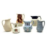 A collection of thirteen Victorian and later pottery jugs
