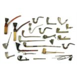 Twenty-two Indian metal and wood-mounted pipes,