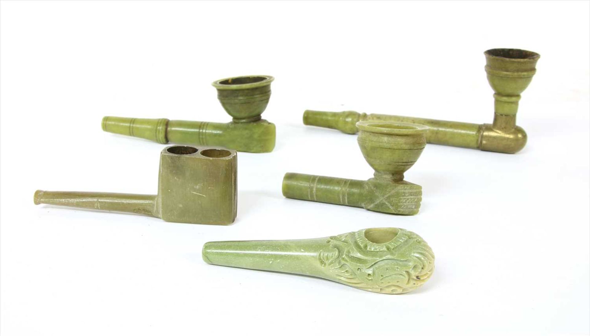 Five green stone tobacco or opium pipes,