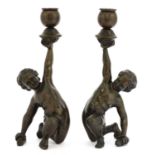 A pair of bronze figural candlesticks,