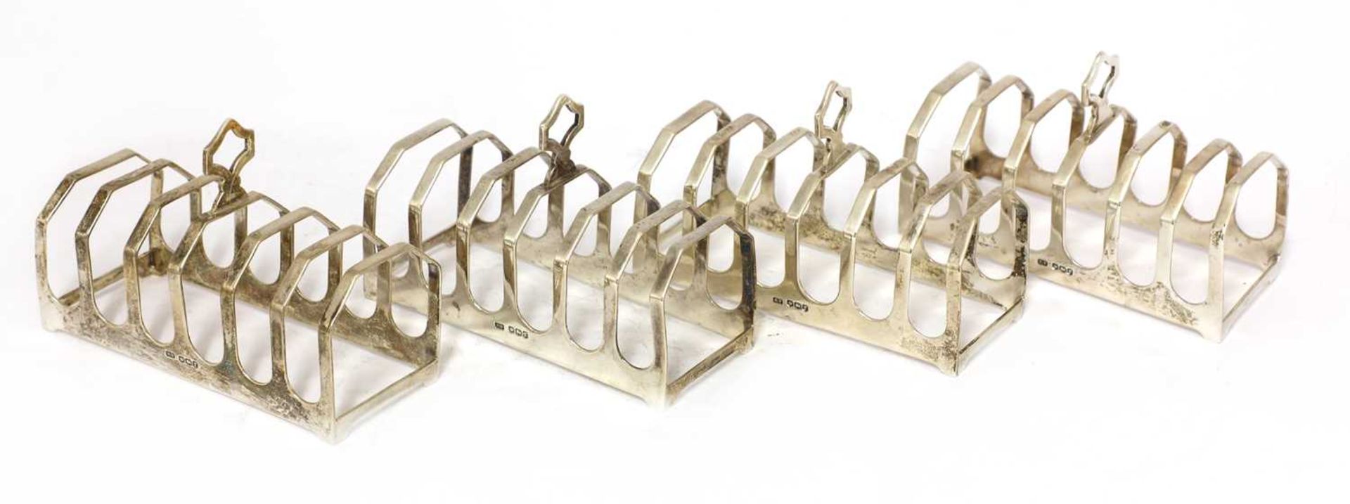 A set of four silver toast racks,