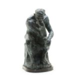 A modern bronze figure of a man, seated,