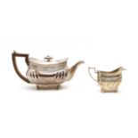 An Edwardian silver teapot and associated milk jug,