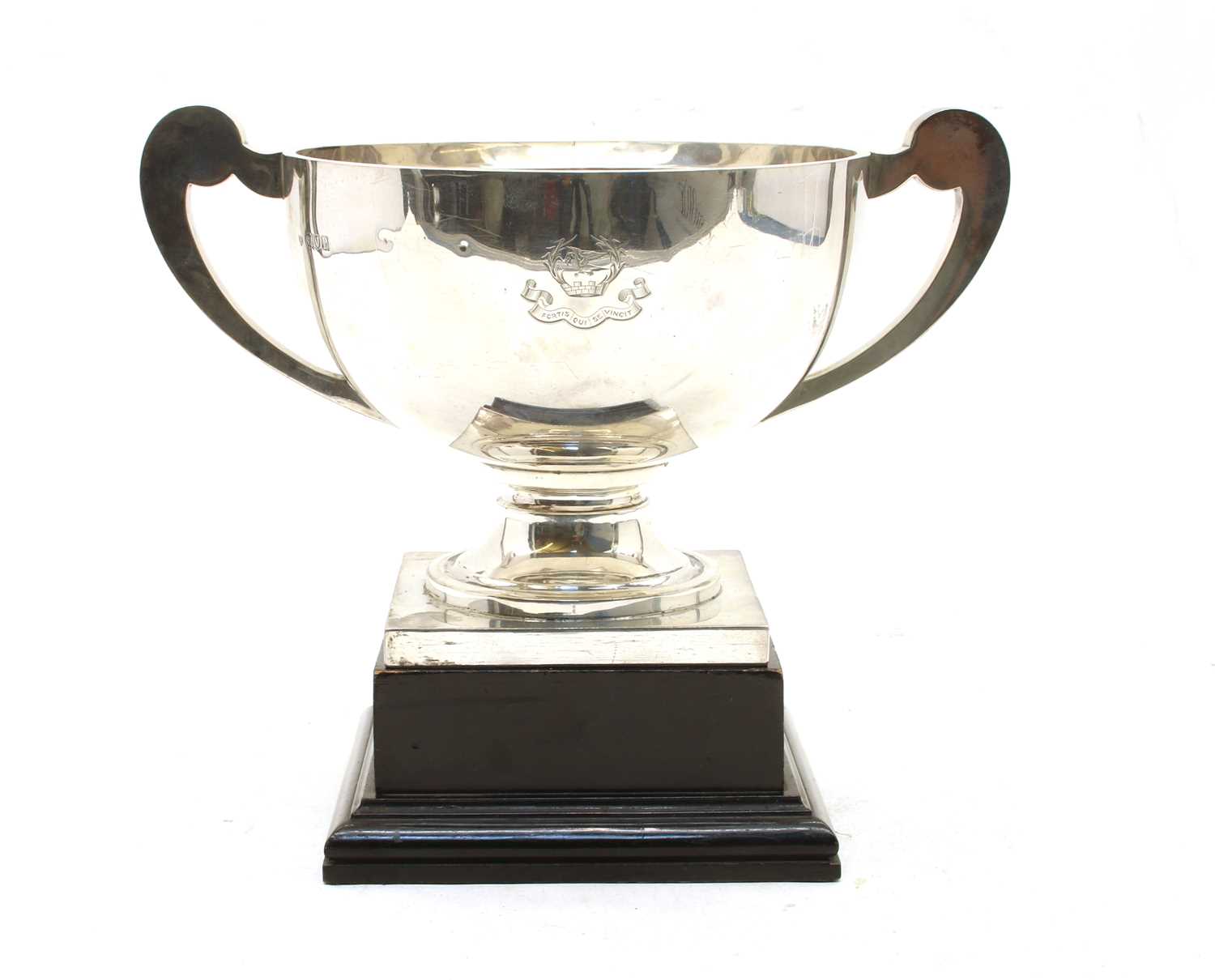 A George V silver twin handled trophy with scroll handles and square plinth base,