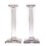 A pair of contemporary glass candlesticks of angular form,