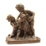 A bronze figure of children feeding a goat,