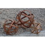 A graduated set of three contemporary rusted metal strapwork spheres,