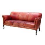 A red leather three-seater settee,