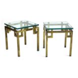 A pair of glass and brass side tables,