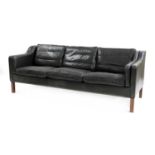 A black leather three-seater sofa,