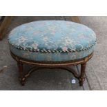 A large oval walnut and gilt stool