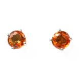 A pair of white gold orange sapphire stud earrings,