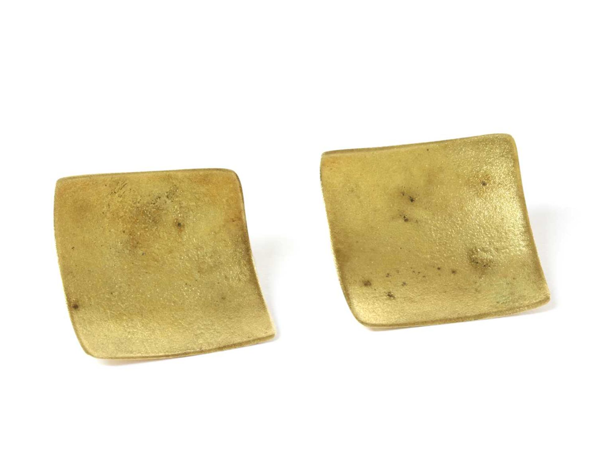 A pair of gold stud earrings,