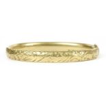 A gold hollow hinged oval bangle,