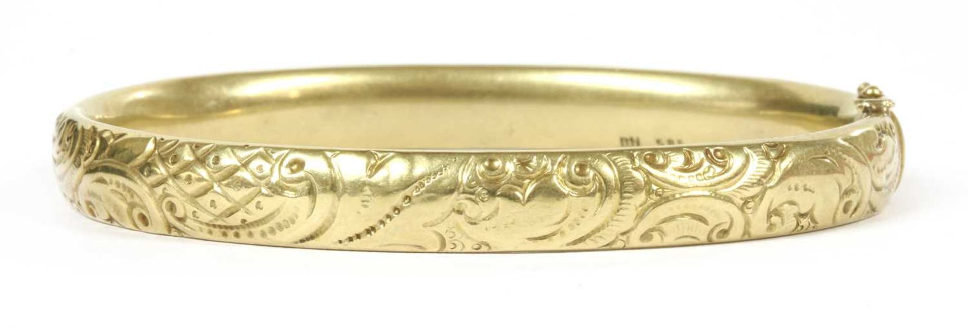 A gold hollow hinged oval bangle,