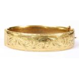 A 9ct gold oval hinged bangle,