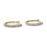A pair of 9ct gold diamond oval hoop earrings,