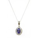 A white gold tanzanite and diamond cluster pendant,