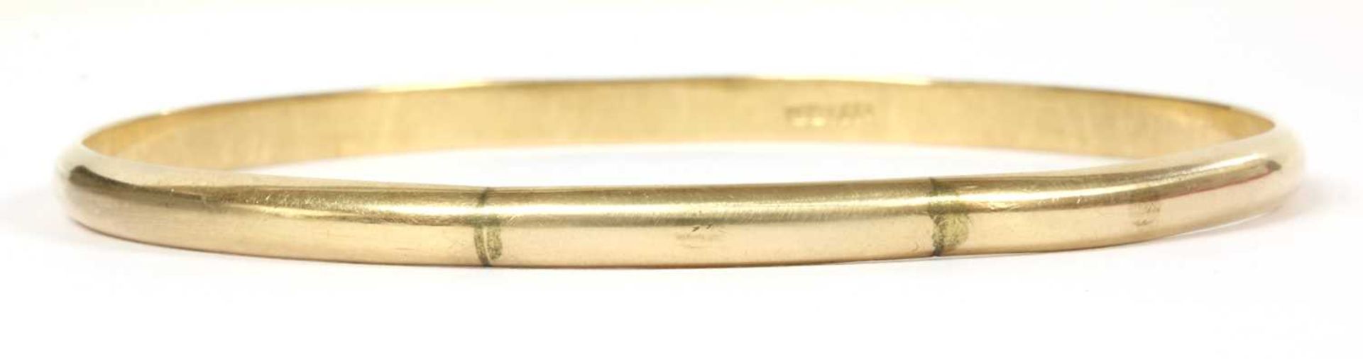 A plain gold D section bangle,