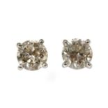 A pair of platinum single stone diamond stud earrings,