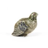 A silver sculpture of a partridge,