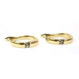 A pair of gold diamond half hoop earrings,