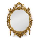 A carved gilt pierced oval wall mirror,