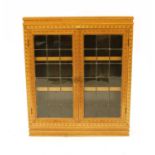 An early 20th Century inlaid oak and parquetry glazed bookcase,